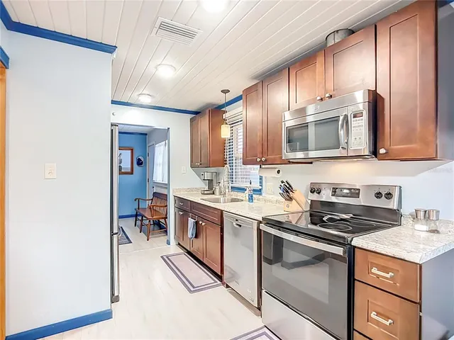 a kitchen with stainless steel appliances granite countertop a stove a sink and a microwave