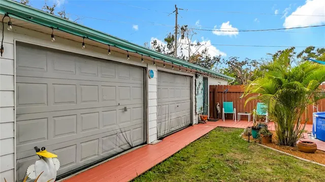 a view of a small house with yard and furniture