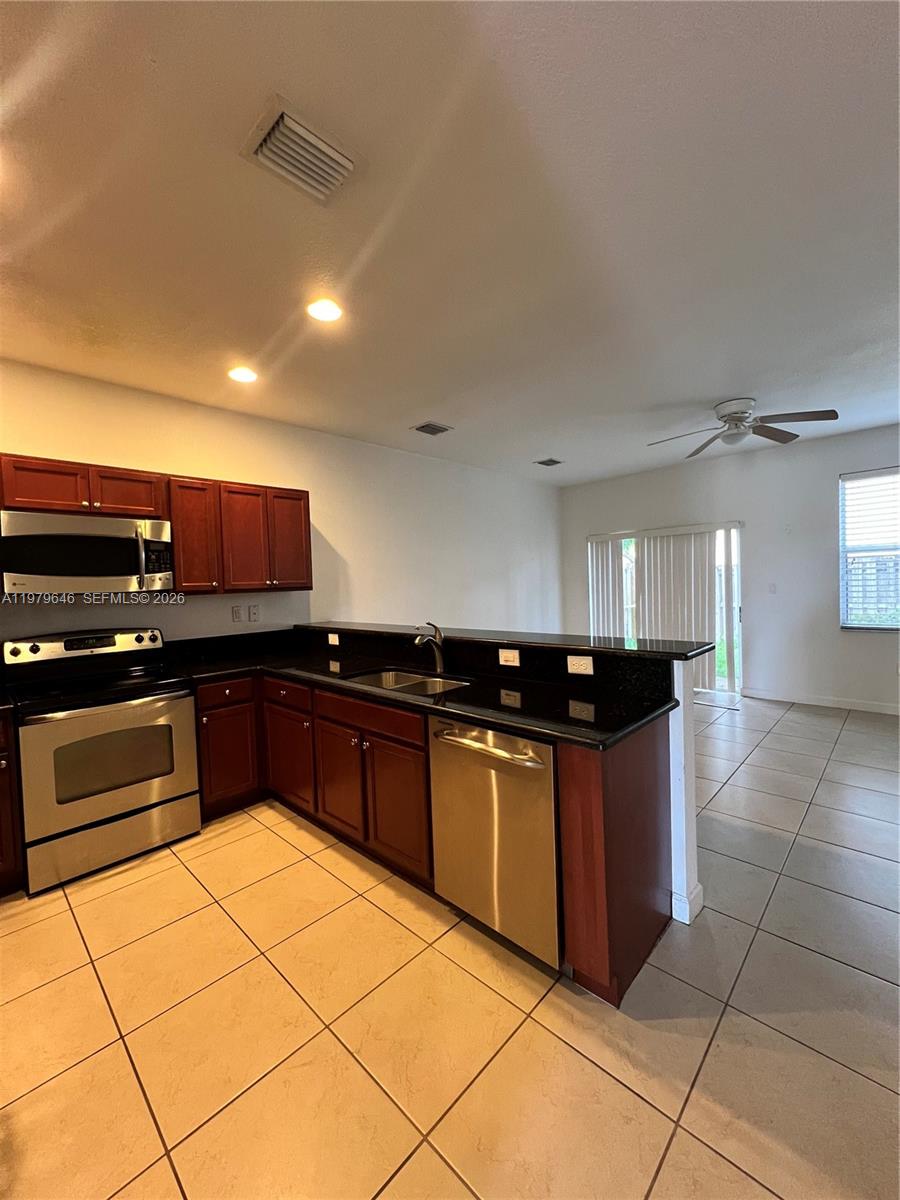 9031 Southwest 227th Street, Unit 2 Cutler Bay, FL 33190 - Photo 4 of 16 a kitchen with stainless steel appliances granite countertop a stove and a sink