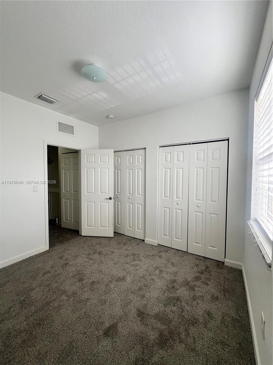 9031 Southwest 227th Street, Unit 2 Cutler Bay, FL 33190 - Photo 10 of 16 an empty room with windows