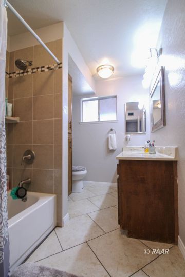 221 South Primrose Street Ridgecrest, CA 93555 - Photo 15 of 29 a bathroom with a bathtub sink vanity and mirror