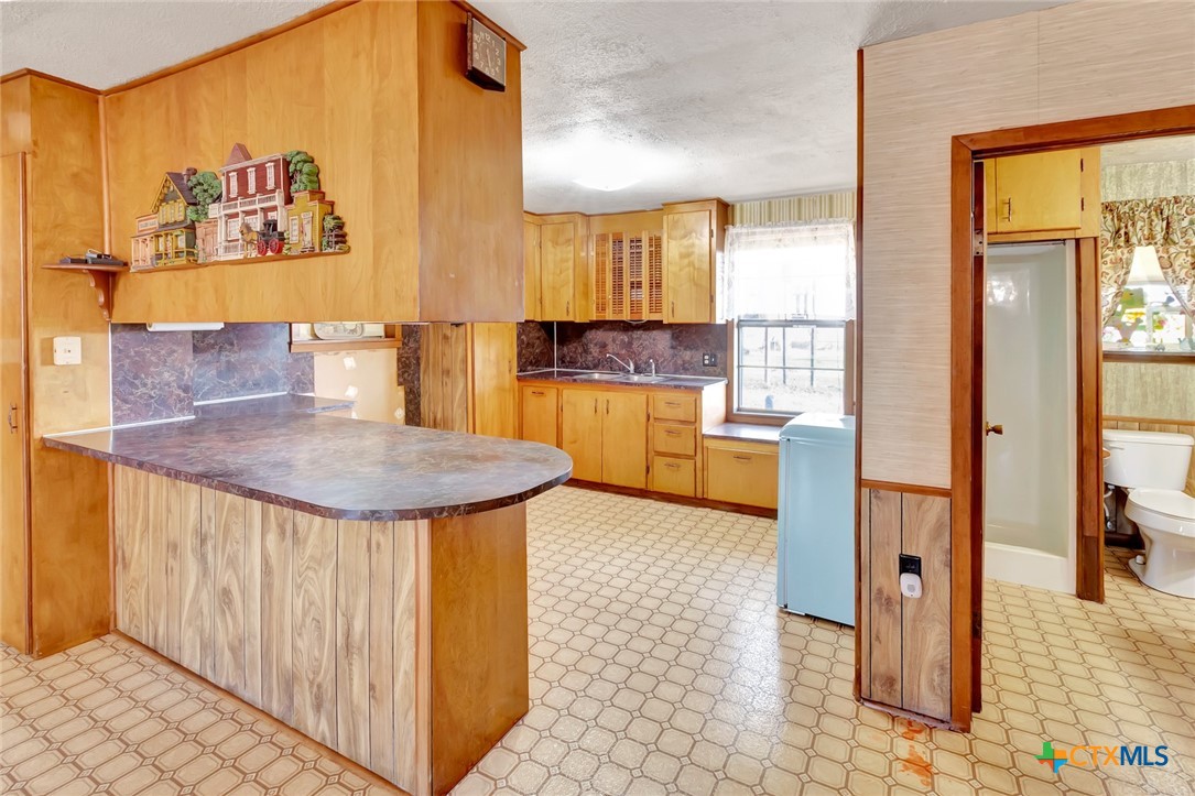 10957 Highway 77 Schulenburg, TX 78956 - Photo 21 of 35 a kitchen with stainless steel appliances kitchen island granite countertop a refrigerator a stove a sink with island and chairs
