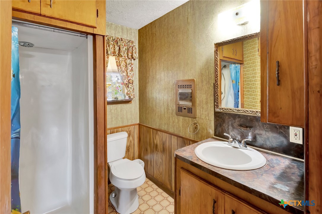 10957 Highway 77 Schulenburg, TX 78956 - Photo 23 of 35 a bathroom with a granite countertop sink toilet and shower