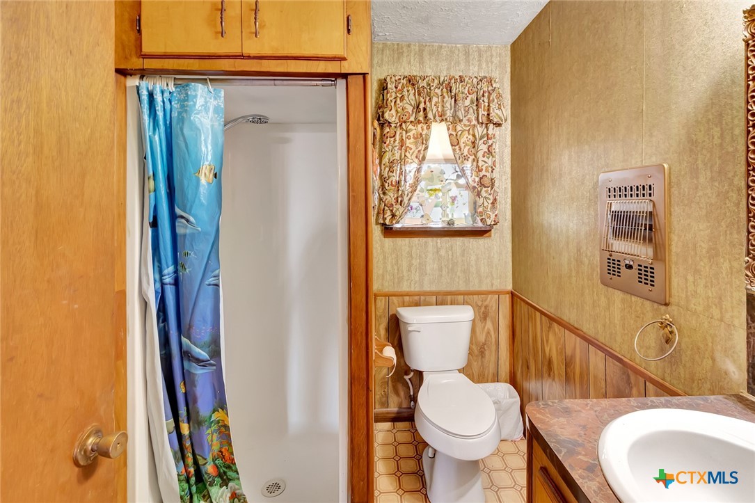 10957 Highway 77 Schulenburg, TX 78956 - Photo 24 of 35 a bathroom with a toilet and a shower curtain