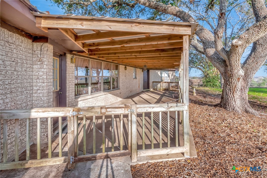 10957 Highway 77 Schulenburg, TX 78956 - Photo 26 of 35 a view of a patio with table and chairs with wooden floor and fence