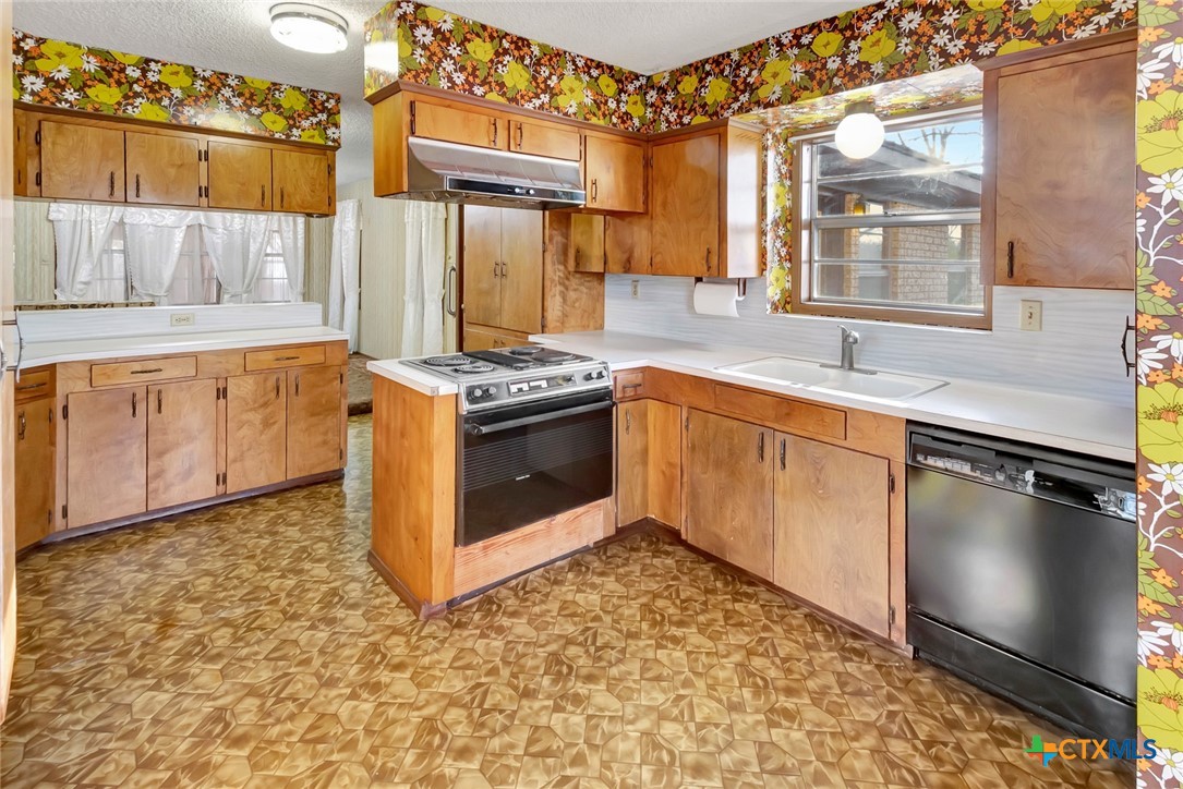 10957 Highway 77 Schulenburg, TX 78956 - Photo 8 of 35 a kitchen with stainless steel appliances granite countertop a stove a sink and a refrigerator