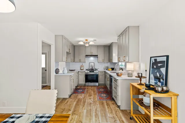 a large kitchen with a lot of counter space and wooden floor