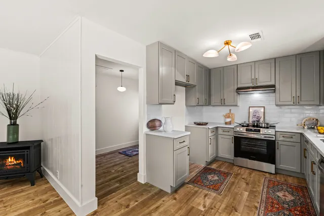 a kitchen with stainless steel appliances granite countertop a stove a sink and a refrigerator