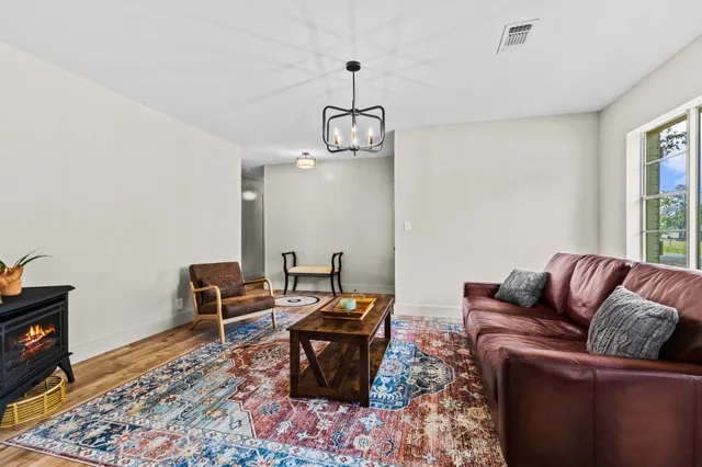 a living room with furniture wooden floor and a window