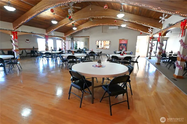 a dining room with wooden floor a chandelier a wooden table and chairs
