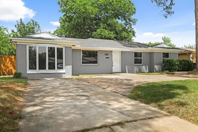 a front view of a house with a garden and yard