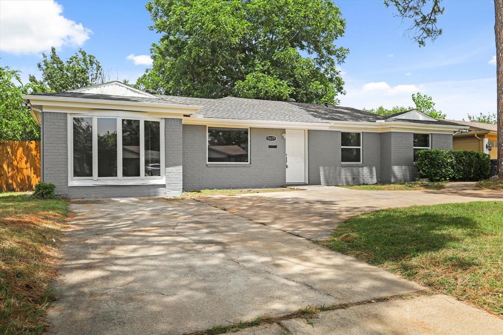 a front view of a house with a garden and yard