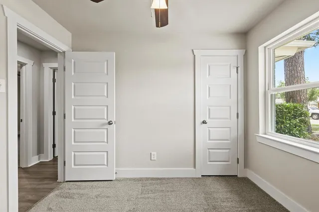 an empty room with windows and closet