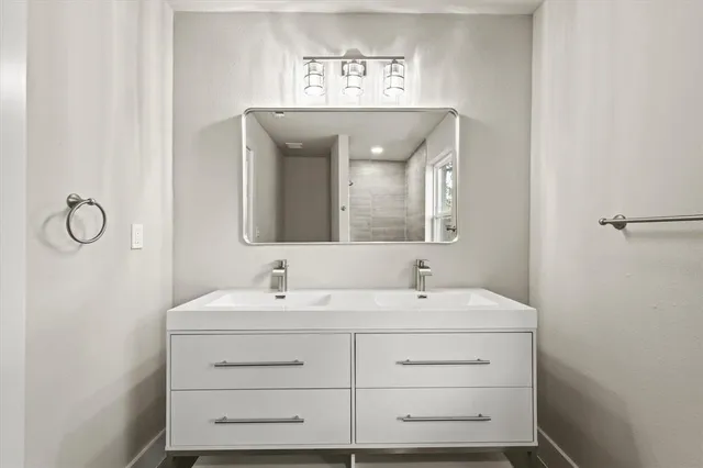 a bathroom with a double vanity sink and a mirror