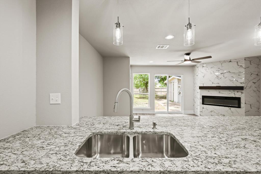 5629 Maceo Lane Fort Worth, TX 76112 - Photo 19 of 25 a kitchen with kitchen island a stove a sink and a counter space