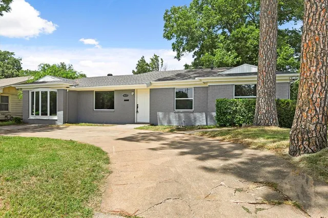 a view of a house with a yard and potted plants