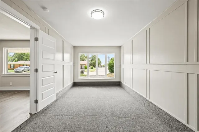 a view of a kitchen with an empty room and windows