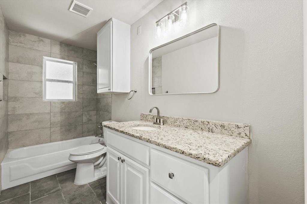 5629 Maceo Lane Fort Worth, TX 76112 - Photo 9 of 25 a bathroom with a granite countertop sink a toilet and a bathtub