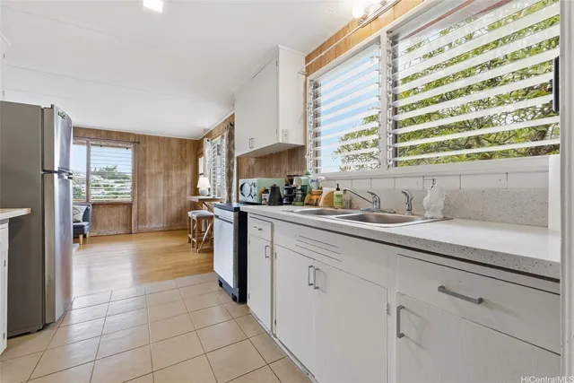 a kitchen with a sink a refrigerator and cabinets