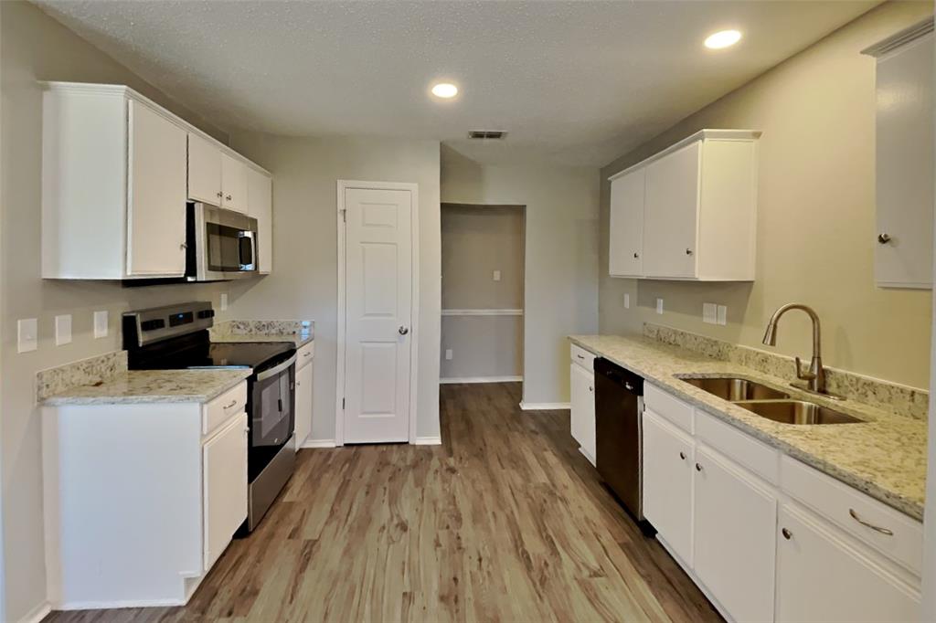 516 Bailey Street Saginaw, TX 76179 - Photo 5 of 19 a kitchen with a sink a counter top space stainless steel appliances and cabinets