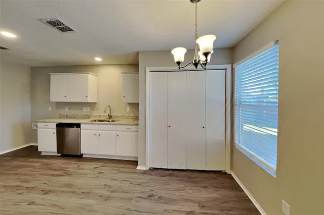 a view of a kitchen with a sink wooden cabinets and appliances