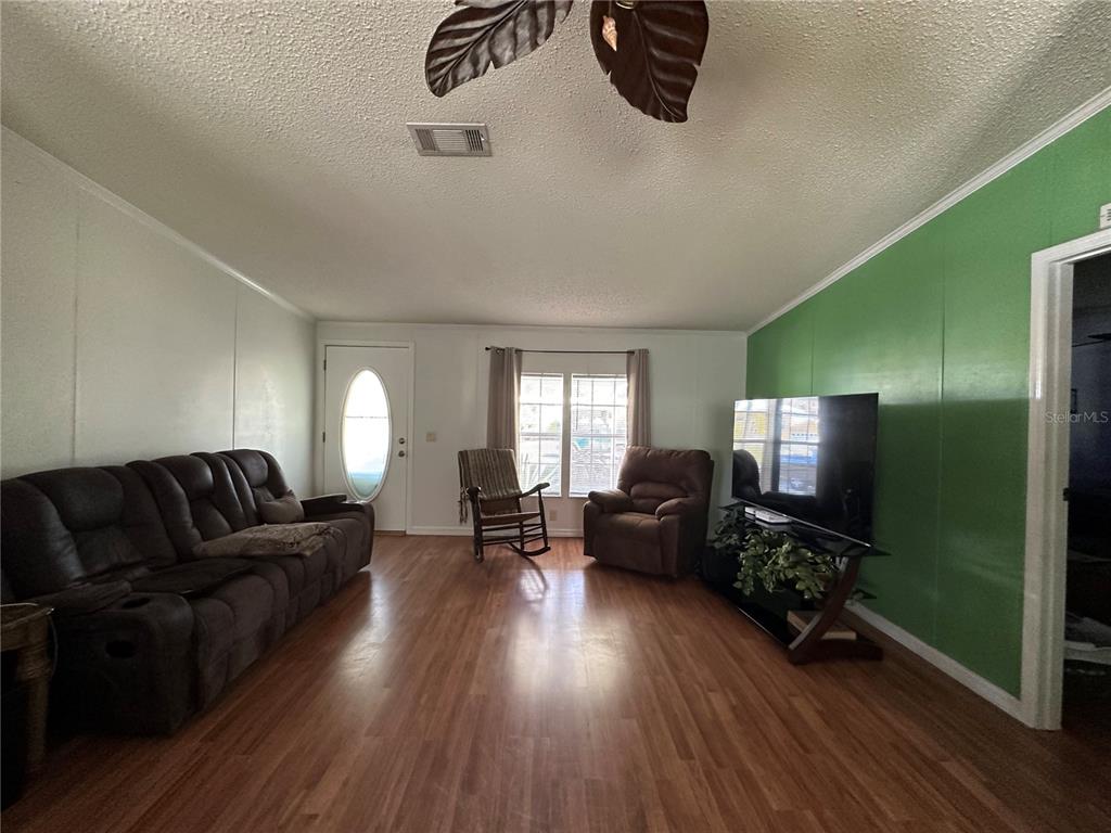 56233 Water Oak Road Astor, FL 32102 - Photo 11 of 50 a living room with furniture and a flat screen tv