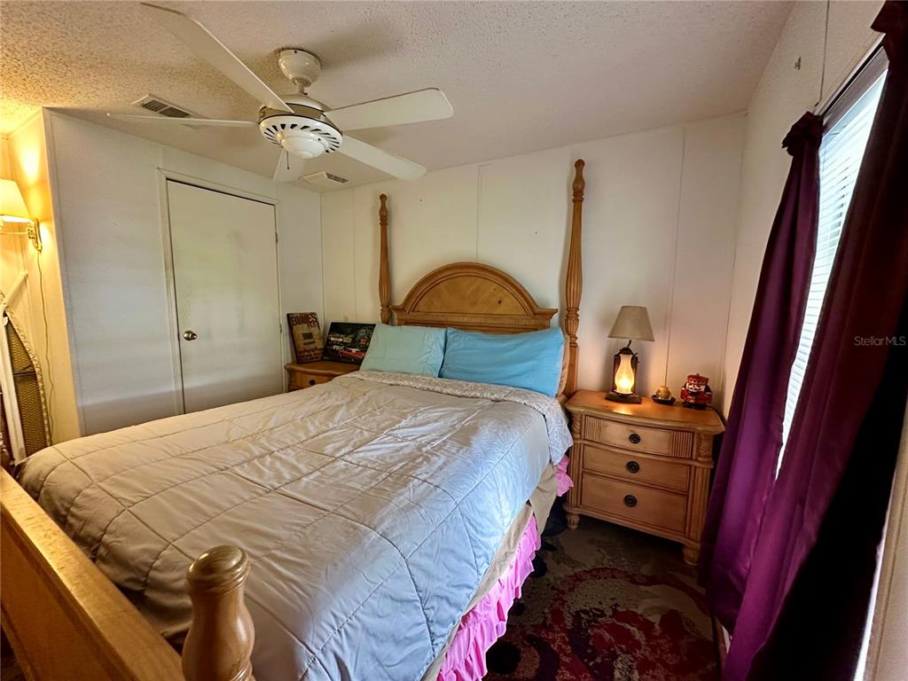 56233 Water Oak Road Astor, FL 32102 - Photo 24 of 50 a bedroom with a bed and a dresser