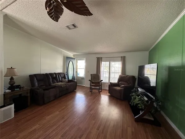 a living room with furniture and a wooden floor