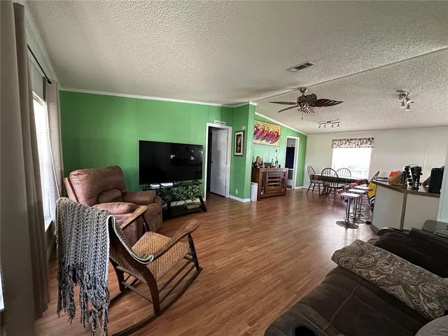 a kitchen with stainless steel appliances kitchen island granite countertop a table chairs in it and a wooden floors