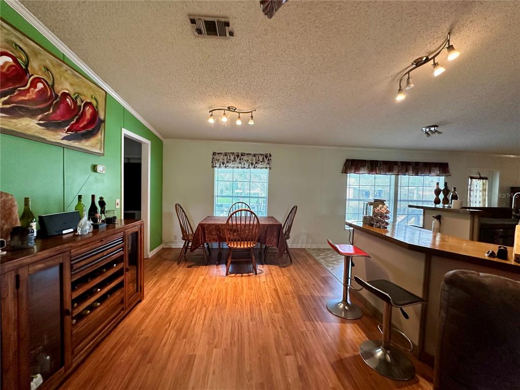 56233 Water Oak Road Astor, FL 32102 - Photo 10 of 50 a kitchen with stainless steel appliances kitchen island granite countertop a table chairs in it and a wooden floors