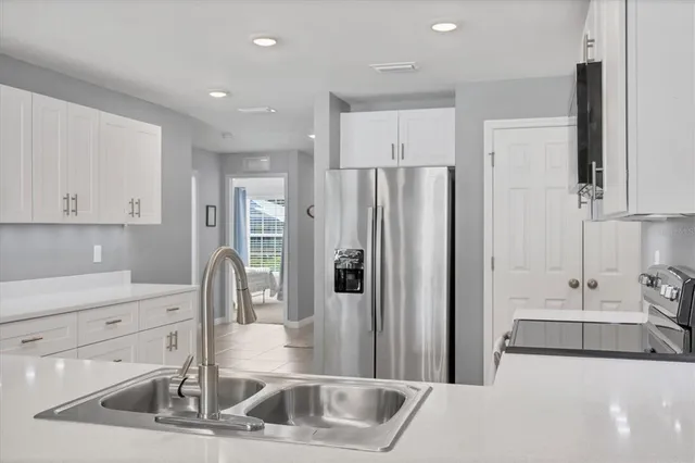 a kitchen with stainless steel appliances granite countertop a refrigerator and a sink