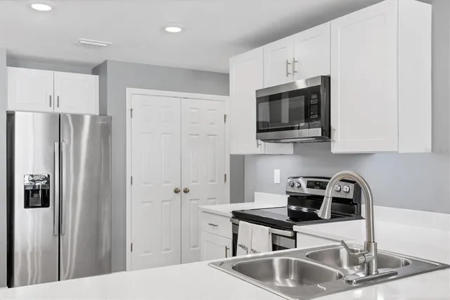 a kitchen with stainless steel appliances granite countertop a refrigerator and a sink