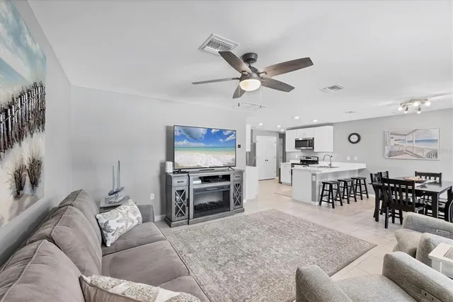 a living room with furniture and a flat screen tv with kitchen view