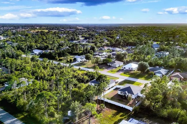 an aerial view of residential houses with outdoor space and trees