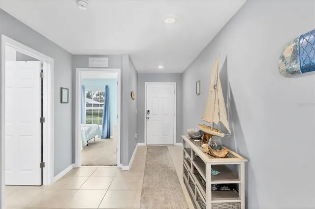 a view of a hallway with bathroom and mirror