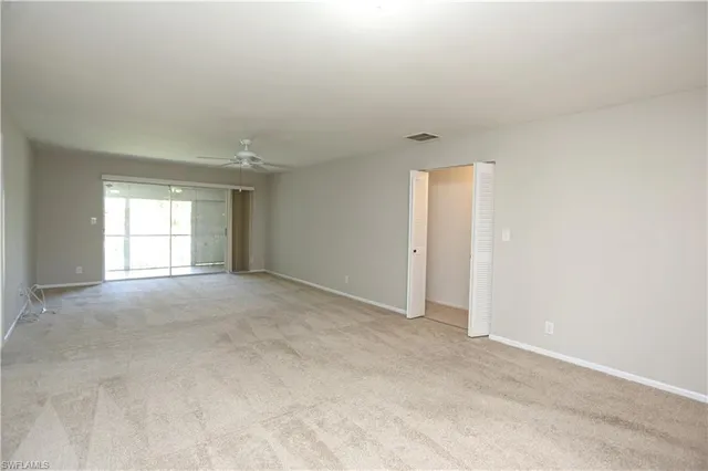 an empty room with closet and a ceiling fan