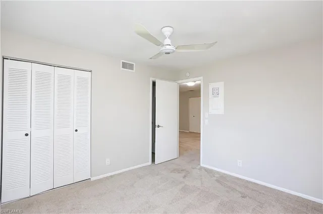 an empty room with a window and ceiling fan