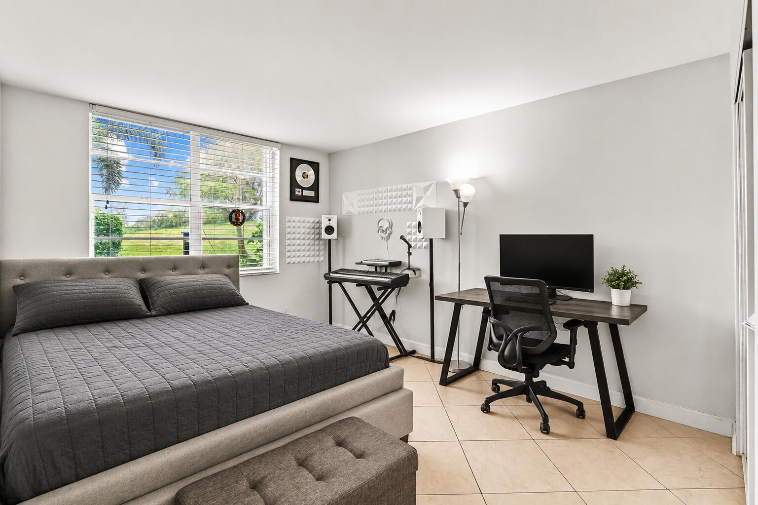 6400 Northwest 2nd Avenue, Unit 124 Boca Raton, FL 33487 - Photo 26 of 33 a bedroom with a bed and a flat screen tv