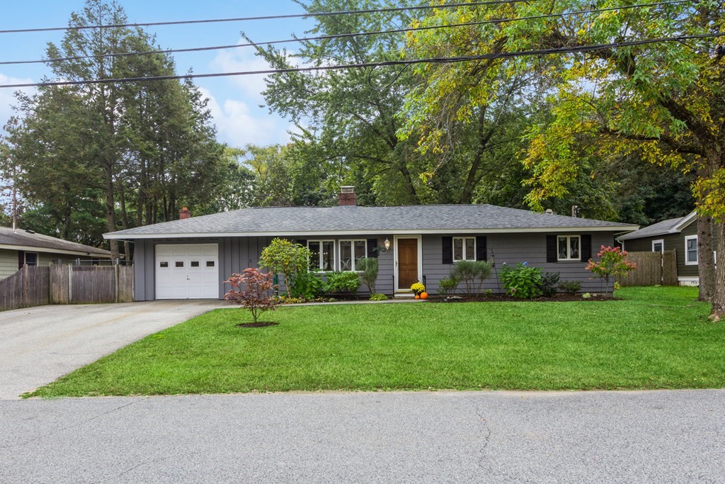 a front view of a house with a garden and trees