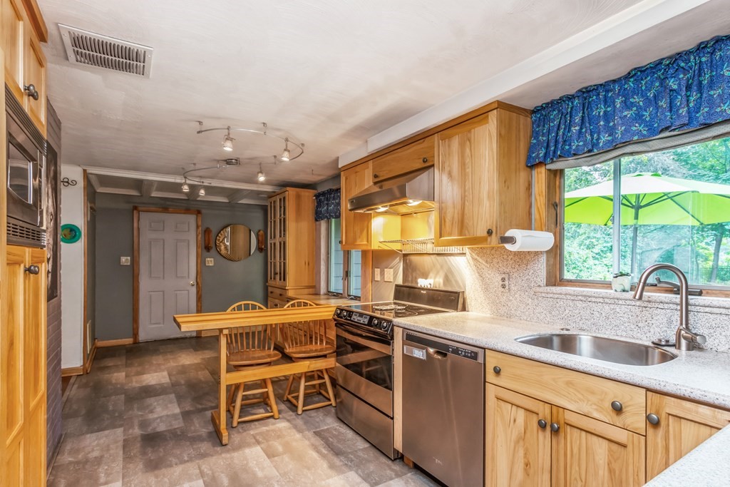 96 Simpson Drive Framingham, MA 01701 - Photo 16 of 35 a kitchen with stainless steel appliances granite countertop sink stove and cabinets