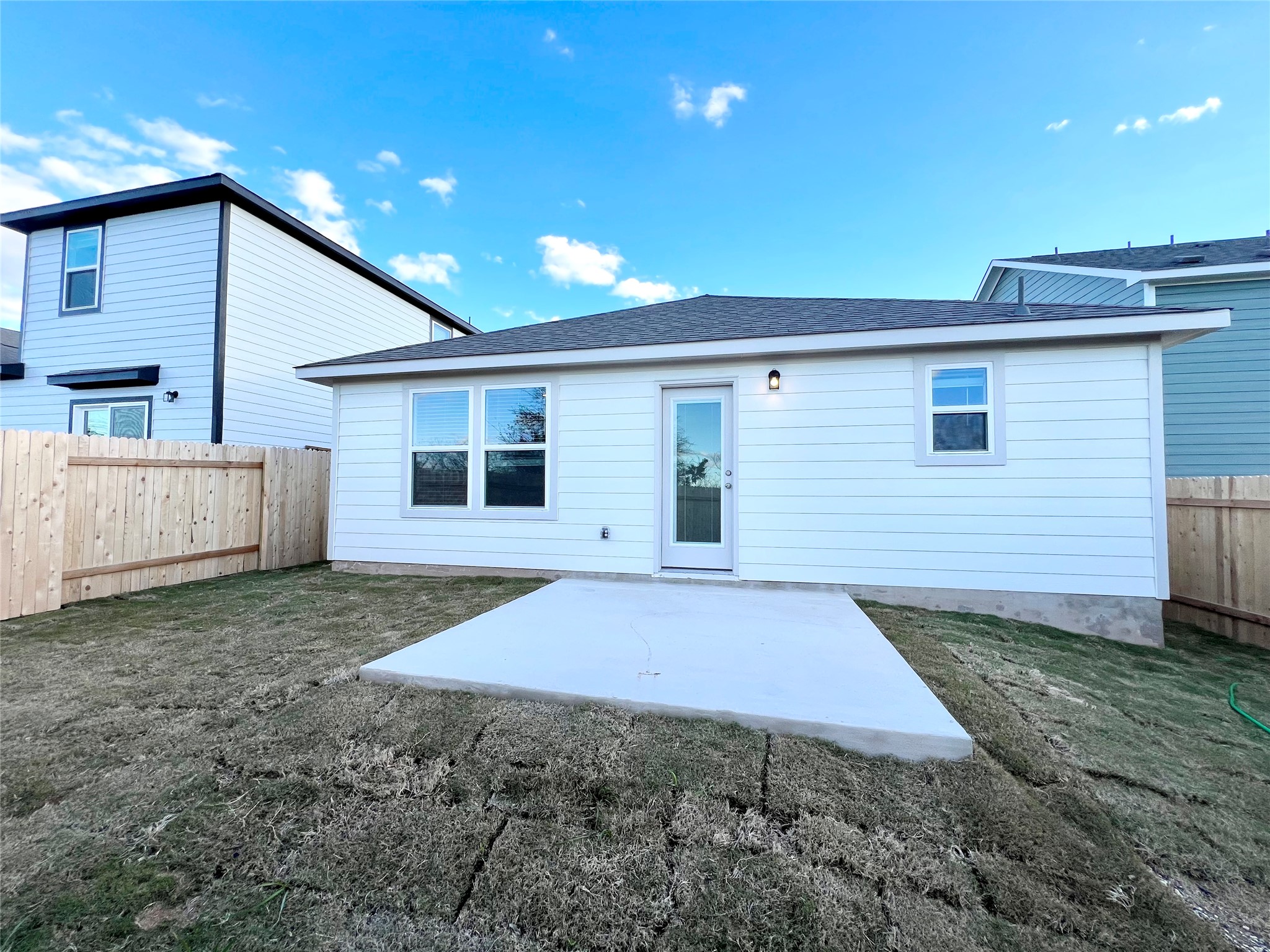325 Alcatraz Loop Jarrell, TX 76537 - Photo 15 of 16 Back of property featuring a fenced backyard, a patio, and roof with shingles