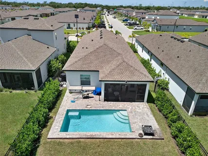 an aerial view of a house with yard swimming pool and outdoor seating