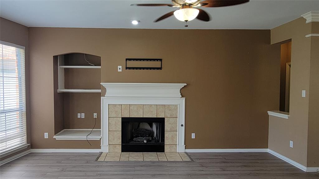 2400 Spillway Circle Frisco, TX 75036 - Photo 13 of 21 a living room with a fireplace and a ceiling fan