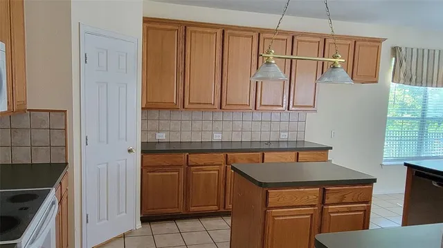 a kitchen with a sink a refrigerator and cabinets