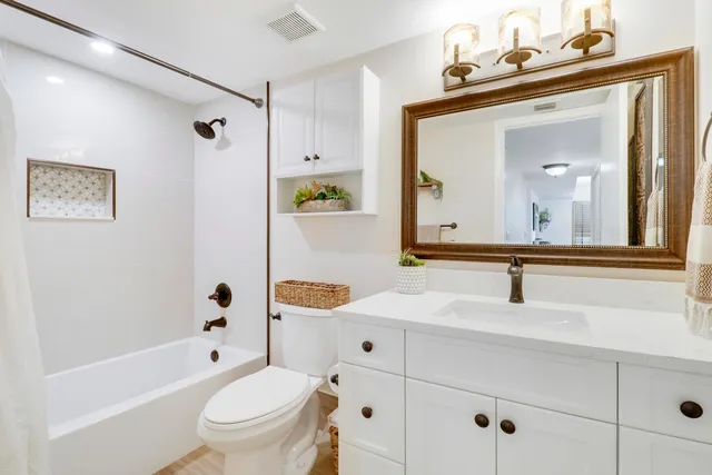 a bathroom with a sink mirror toilet and bathtub