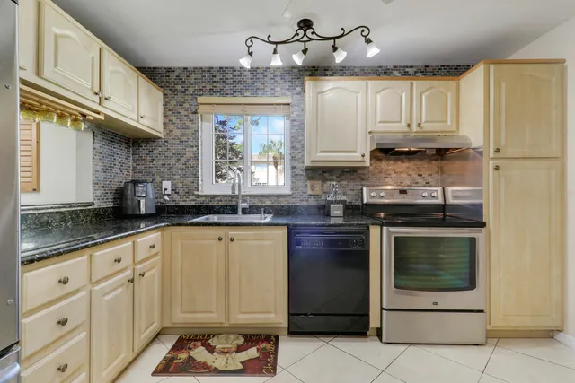 a kitchen with granite countertop white cabinets white stainless steel appliances with a sink and dishwasher