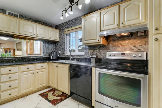 a kitchen with granite countertop a stove sink and cabinets