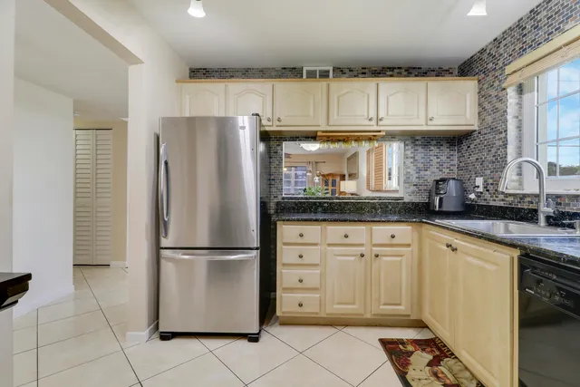a kitchen with stainless steel appliances granite countertop a refrigerator and a stove top oven