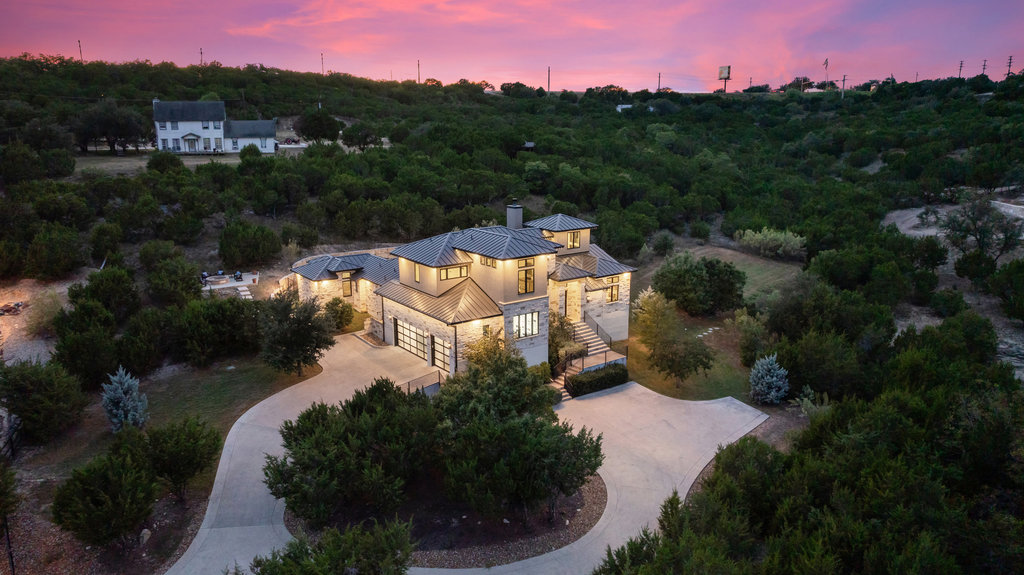 an aerial view of residential houses with outdoor space and trees