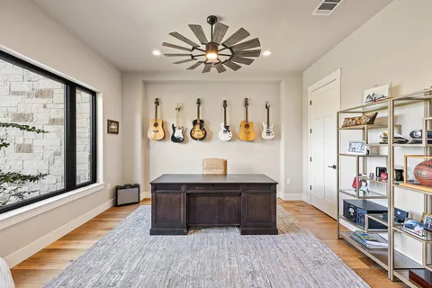 a view of workspace with wooden floor and fan
